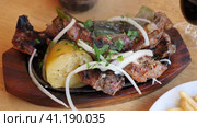 Grilled lamb ribs, potato and pepper decorated with fresh cut onion and greens. Стоковое видео, видеограф Яков Филимонов / Фотобанк Лори