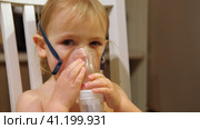 Sick Baby Girl with making Inhalation with a Mask on his Face sitting in Living Room at Home. Children Healing. Child Inhalation therapy with Compressor nebulizer. Inhaling fumes medication into lungs. Стоковое видео, видеограф Марина Демидюк / Фотобанк Лори
