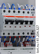 electric circuit breakers installed on a din rail in an electric switchboard. (2023 год). Редакционное фото, фотограф Нелик Дулатов / Фотобанк Лори