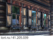 Окна с деревянными ставнями и резными наличниками. Редакционное фото, фотограф Евгений Фомичев / Фотобанк Лори