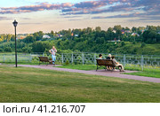 July 23, 2022 Russia Tver region Rzhev city. People sit on a bench on the embankment of the Volga River. Редакционное фото, фотограф Алексей Сорокин / Фотобанк Лори