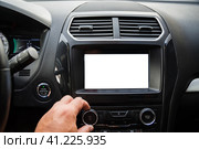 The male driver is adjusting the volume of  the car audio system. Водитель-мужчина регулирует громкость автомобильной аудиосистемы. Стоковое фото, фотограф Дмитрий Березнев / Фотобанк Лори