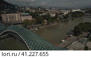 Пешеходный мост Мира через реку Кура в центре столицы Грузии. Вид на старый город.Тбилиси. Грузия 04.09.23 (2023 год). Редакционное видео, видеограф Ярославский Максим / Фотобанк Лори