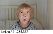 5 years Boy joking, sticking tongue out with silly expression. Child making face. Funny foolishness portrait of little boy in white bedroom. Adorable caucasian kid making crazy and comical gesture. Стоковое видео, видеограф Марина Демидюк / Фотобанк Лори