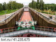 Vytegra, Russia - August 16, 2015: Cargo ship entered the White Sea-Baltic Canal Gateway. It connects the White Sea, in the Arctic Ocean, with Lake Onega, which is further connected to the Baltic Sea. Редакционное фото, фотограф VittoriaChe / Фотобанк Лори