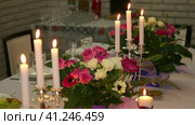 Beautiful banquet table setting with burning candles and fresh flowers. Romantic candlelit dinner. Beautiful banquet table. Красивая сервировка банкетного стола с горящими свечами и свежими цветами. Романтический ужин при свечах. Красивый банкетный стол. Стоковое видео, видеограф Egor Sarantstv / Фотобанк Лори