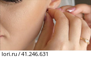 The girl wears jewelry, earrings on her ears.High quality FullHD footage. Девушка носит украшения, серьги в ушах. Стоковое видео, видеограф Egor Sarantstv / Фотобанк Лори