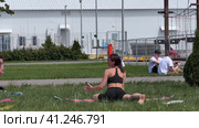 Russia, Nizhny Novgorod, VUO, Volga embankment 43 06.05.2023. A young woman is doing yoga on the street, in a beautiful meadow in summer.  Россия, Нижний Новгород, ВУО, Волжская набережная, 43 06.05.2023. Молодая женщина занимается йогой на улице, на прекрасном лугу летом. (2021 год). Редакционное видео, видеограф Egor Sarantstv / Фотобанк Лори