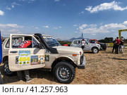 SUVs with specially reinforced suspension stand in the field before the start of the rally (2023 год). Редакционное фото, фотограф Сергей Сергеев / Фотобанк Лори