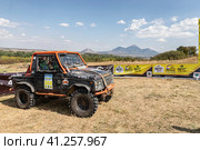 Racing off-road vehicles are lined up for display and inspection before the competition against the backdrop of Mount Beshtau (2023 год). Редакционное фото, фотограф Сергей Сергеев / Фотобанк Лори