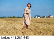 Young beautiful brunette model in a beige dress posing against the background of a mowed wheat field. Стоковое фото, фотограф Андрей Аркуша / Фотобанк Лори