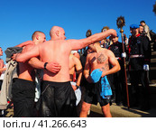 Sremska Mitrovica, Serbia, January 19, 2022. Christian holiday Epiphany. Mass bathing of people in the river in winter. Epiphany bathing. Редакционное фото, фотограф Юлия Петровская / Фотобанк Лори