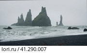 The black sand beach of Reynisfjara with waves hitting the shore on foggy rainy stormy day Vik, Icel. Стоковое фото, фотограф Igor Tichonow / Фотобанк Лори