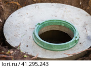 Construction of a septic tank. Large concrete rings embedded in the ground, from above an open sewer hatch, unprotected by a cover from falling. Стоковое фото, фотограф Коханова Наталья / Фотобанк Лори