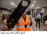 Сотрудник безопасности метрополитена проверяет сумки на входе в метро Сокольники города Москвы, Россия (2023 год). Редакционное фото, фотограф Николай Винокуров / Фотобанк Лори