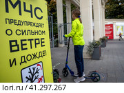 Баннер с предупреждением МЧС о сильном ветре и дожде установлен для посетителей парка Сокольники города Москвы, Россия (2023 год). Редакционное фото, фотограф Николай Винокуров / Фотобанк Лори