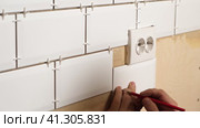 Male Worker Master Laying Ceramic Tiles on the Wall of Kitchen. Repairman Placing White Modern Tiles, Spreading Adhesive. Builder Installing Tile at Repair Renovation Work. Professional Tiling. 4K. Стоковое видео, видеограф Марина Демидюк / Фотобанк Лори