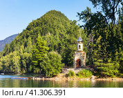 Beautiful summer landscape with Orthodox Chapel of Holy Solomon on shore of warm Emerald Lake against backdrop of Monomakh Cap mountain near Baikal. Popular tourist spot, local landmark. Стоковое фото, фотограф Виктория Катьянова / Фотобанк Лори