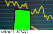 Black phone with blank mockup screen on rising stock graph. Closeup hand showing smartphone isolated green display. Online banking, Fund App use. Financial analyst on Invest Market. Bank collapse 2023. Стоковое видео, видеограф Марина Демидюк / Фотобанк Лори