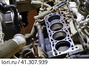 The cylinder block of the four-cylinder engine. Disassembled motor vehicle for repair. Parts in engine oil. Car engine repair in the service. Стоковое фото, фотограф Леонид Еремейчук / Фотобанк Лори