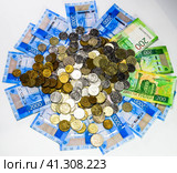 Russian banknotes and coins. A handful of coins on new Russian banknotes in denominations of 2000 and 200 rubles. Стоковое фото, фотограф Леонид Еремейчук / Фотобанк Лори