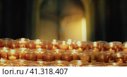 Burning candles in the church. Orthodox cross with crucifixion of Jesus Christ. Christian faith in G. Стоковое видео, видеограф Ольга Сухарева / Фотобанк Лори