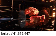 The meat is grilled in an electric oven. Three pieces of pork are processed with spices. The skewer rotates. The backlight is on. Стоковое видео, видеограф Вера Ивановна Кубарева / Фотобанк Лори