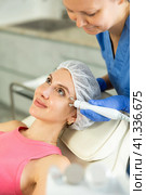 Adult woman cosmetologist doing microcurrent procedure to young woman. Стоковое фото, фотограф Яков Филимонов / Фотобанк Лори