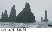 The black sand beach of Reynisfjara with waves hitting the shore on foggy rainy stormy day Vik, Icel. Стоковое видео, видеограф Igor Tichonow / Фотобанк Лори