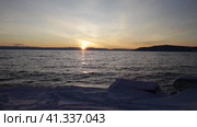 Video of snowy coast of Baikal Lake at sunset in December. Beautiful seascape. Natural background. Стоковое видео, видеограф Виктория Катьянова / Фотобанк Лори