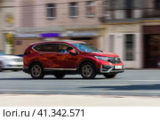 Honda CR-V car is driving in the cityscape. Side view of red SUV in motion. Редакционное фото, фотограф Константин Григорьев / Фотобанк Лори