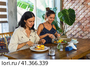 two beautiful women friends eating breakfast in cafe and talking. Стоковое фото, фотограф Татьяна Терехина / Фотобанк Лори