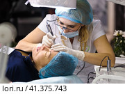 Cosmetologists perform a procedure to rejuvenate facial skin cosmetics Aravia at the festival of beauty Nevskie Berega in St. Petersburg 2012. Редакционное фото, фотограф Анна Кривицкая / Фотобанк Лори