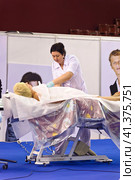 Cosmetologists perform a procedure to rejuvenate facial skin cosmetics Aravia at the festival of beauty Nevskie Berega in St. Petersburg 2012. Редакционное фото, фотограф Анна Кривицкая / Фотобанк Лори