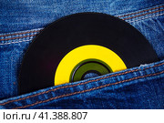 A vinyl disc in jeans. Виниловый диск в джинсах. Стоковое фото, фотограф Алексей Герман / Фотобанк Лори
