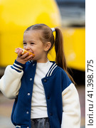 Fast food truck and people eat burger. Cute little girl eating fast food hamburger, hot dog, standing near outdoor cafe stall in city park, urban scene background. Стоковое фото, фотограф Ирина Михайличенко / Фотобанк Лори