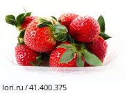 Ripe strawberries in a plastic package on a white background. Delicious fresh berries in a container for sale to customers. Keeping food fresh. Healthy food, vitamins and microelements. Стоковое фото, фотограф Юлия Петровская / Фотобанк Лори