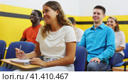 Cheerful young caucasian woman and african-american man sitting at desk in classroom of school for taxi drivers. Стоковое видео, видеограф Яков Филимонов / Фотобанк Лори