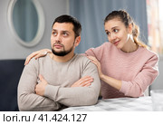 Woman apologizing to offended boyfriend after quarrel at home. Стоковое фото, фотограф Яков Филимонов / Фотобанк Лори