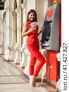 Happy brunette woman withdrawing money from credit card at ATM. Стоковое фото, фотограф Андрей Аркуша / Фотобанк Лори