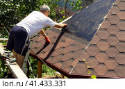 The roofer smears mastic for gluing slate. Стоковое фото, фотограф Светлана Зотова / Фотобанк Лори