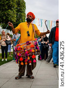 Indian drummer playing traditional dhol instrument in the street. Fest day of india in Moscow (2023 год). Редакционное фото, фотограф Константин Григорьев / Фотобанк Лори