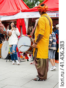 Indian drummer playing traditional dhol instrument in the street. Fest day of india in Moscow (2023 год). Редакционное фото, фотограф Константин Григорьев / Фотобанк Лори