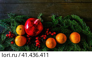 Christmas composition with pomegranate, tangerines and spruce branch. Стоковое фото, фотограф Галина Царькова / Фотобанк Лори