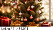 Close-up of a Christmas tree with festive ornaments and gifts. AI-generated image. Стоковое AI-изображение, AI-художник Галина Царькова / Фотобанк Лори