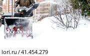 Snowblower removes snow, a man cleans the yard outside. Стоковое фото, фотограф Igor Skripachev / Фотобанк Лори