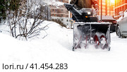Snowblower removes snow, a man cleans the yard outside. Стоковое фото, фотограф Igor Skripachev / Фотобанк Лори