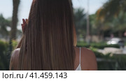 Close-up of long hair of a young girl walking through a tropical garden. Стоковое видео, видеограф Aleksey Kidisyuk / Фотобанк Лори