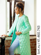 African model woman in a green spring jacket and blue pants. Стоковое фото, фотограф Андрей Аркуша / Фотобанк Лори