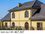 House of yellow brick and brown corrugated roof made of metal. Lattices on the windows. Стоковое фото, фотограф Леонид Еремейчук / Фотобанк Лори